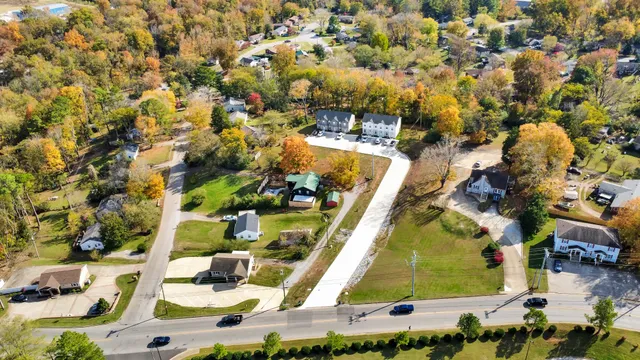 an aerial view of a house with swimming pool and large trees