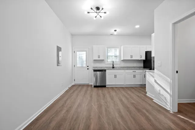 a kitchen with white cabinets sink and stainless steel appliances