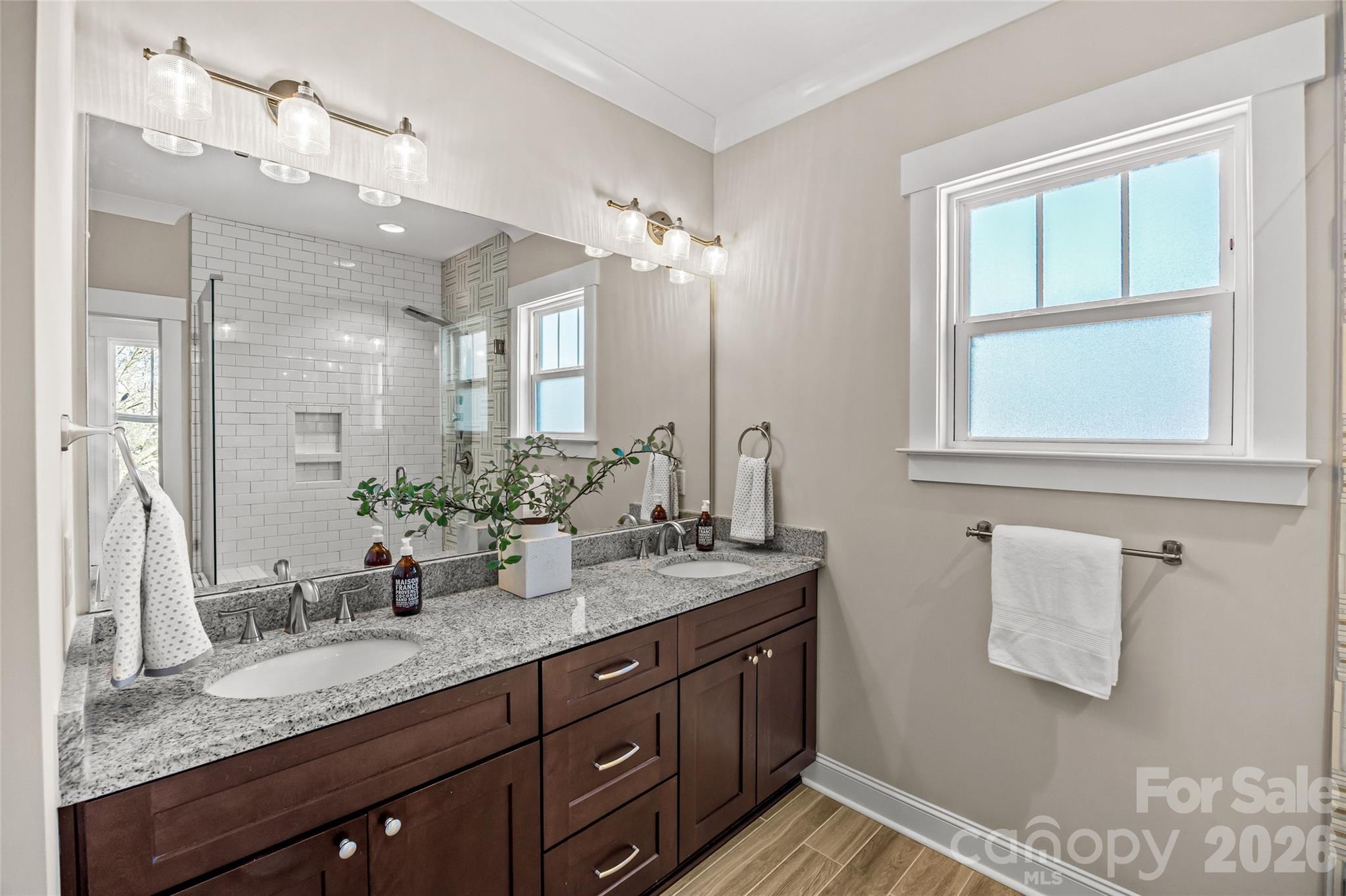 1728 Burgin Street Charlotte, NC 28205 - Photo 24 of 43 a bathroom with a granite countertop sink a mirror and a shower