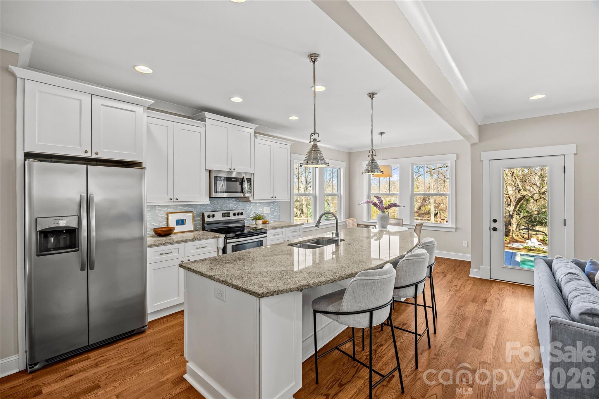 1728 Burgin Street Charlotte, NC 28205 - Photo 10 of 43 a kitchen with granite countertop a table chairs microwave and refrigerator