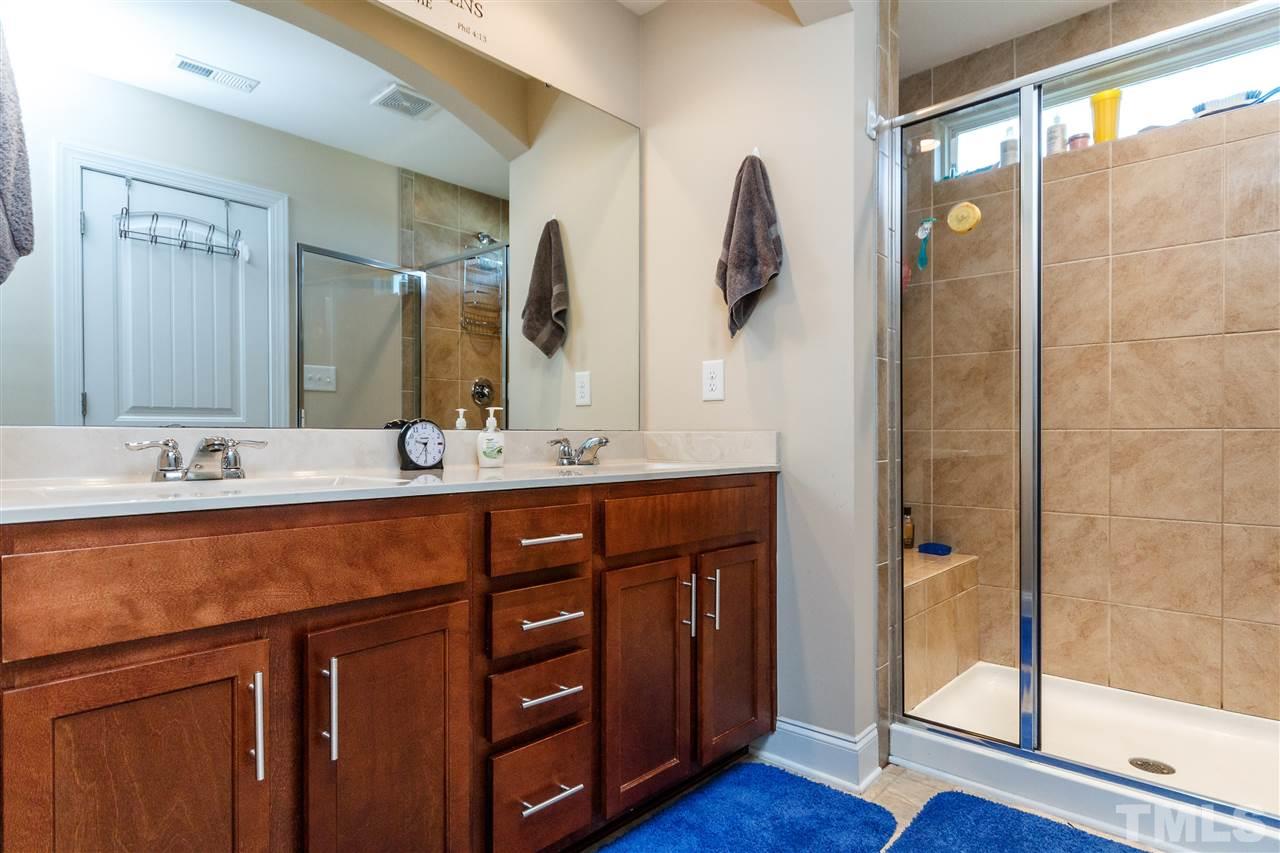 141 Token House Road Durham, NC 27703 - Photo 18 of 22 Master Bath with double vanity and beautiful cabinetry. Glass enclosed tile surround shower with seat.