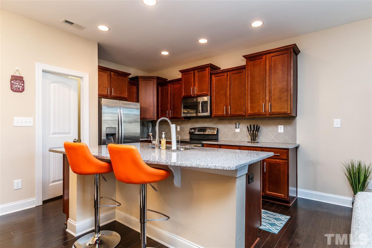 141 Token House Road Durham, NC 27703 - Photo 4 of 22 Fantastic Kitchen with SS appliances, granite counter tops, large eat-in island, beautiful cabinets and hardwood flooring.