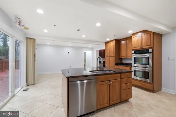 a kitchen with stainless steel appliances granite countertop a refrigerator and a stove top oven