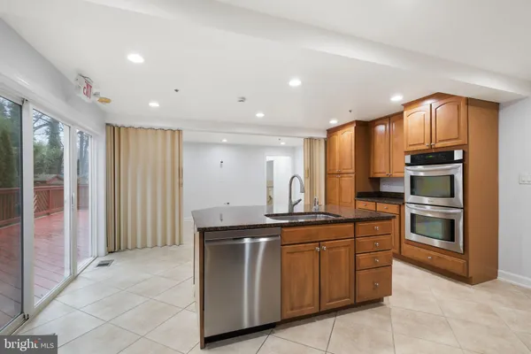 a large kitchen with a large counter top stainless steel appliances and cabinets