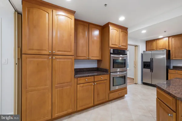 a large kitchen with stainless steel appliances granite countertop a large counter top and a stove top oven
