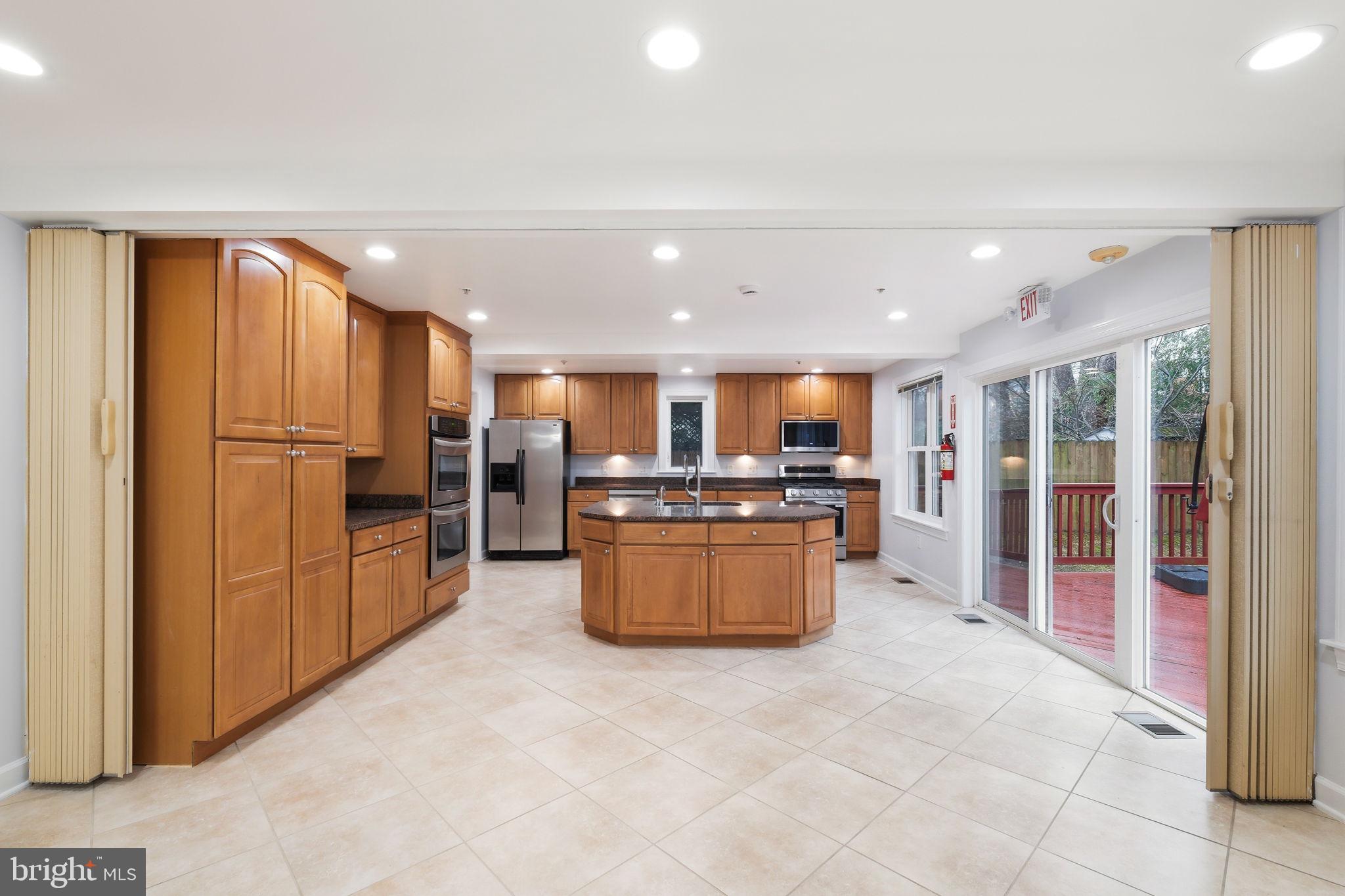 711 Lamberton Drive Silver Spring, MD 20902 - Photo 18 of 60 a large kitchen with a large counter top stainless steel appliances and cabinets