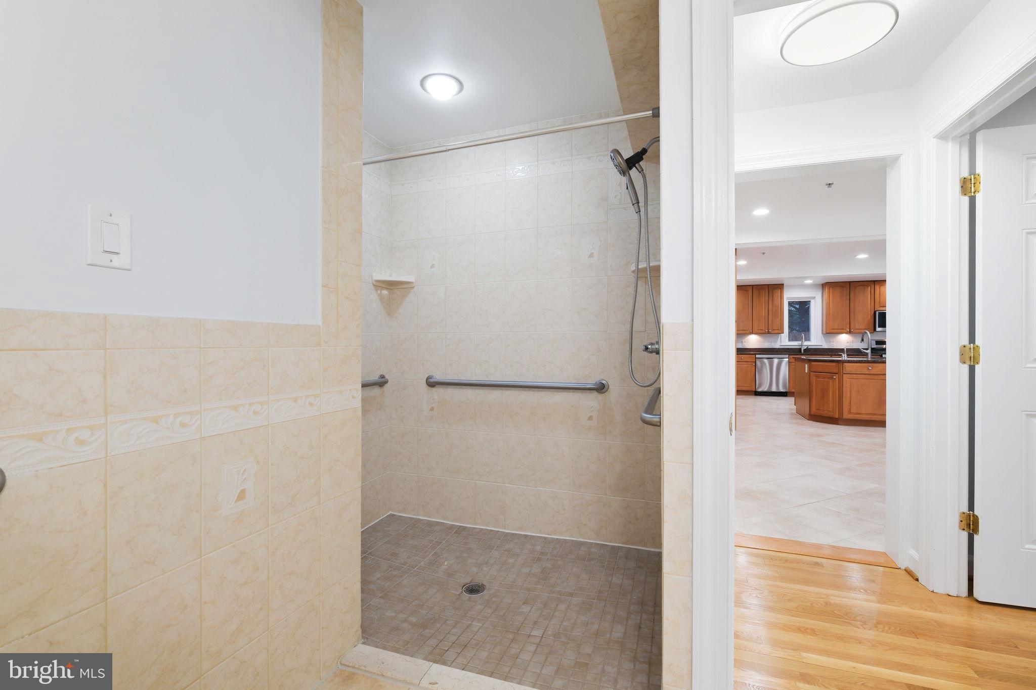 711 Lamberton Drive Silver Spring, MD 20902 - Photo 24 of 60 a bathroom with a glass shower door and a glass door
