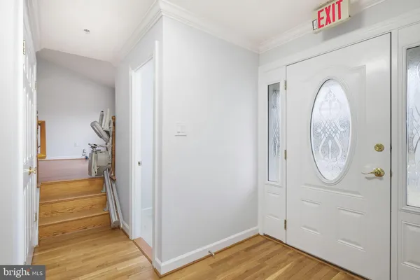 a view of a hallway with wooden floor and a living room