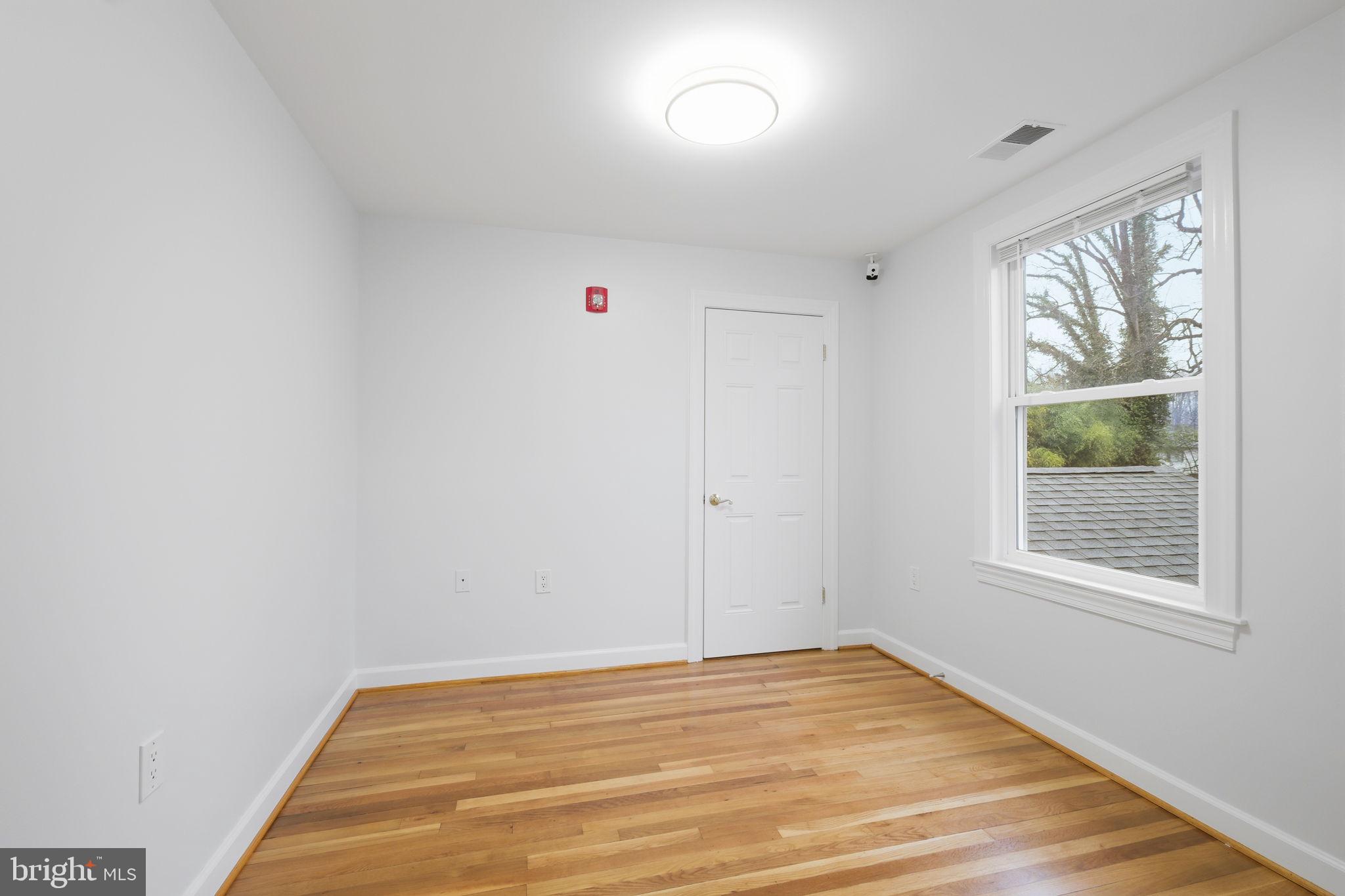711 Lamberton Drive Silver Spring, MD 20902 - Photo 37 of 60 a view of an empty room with wooden floor and a window