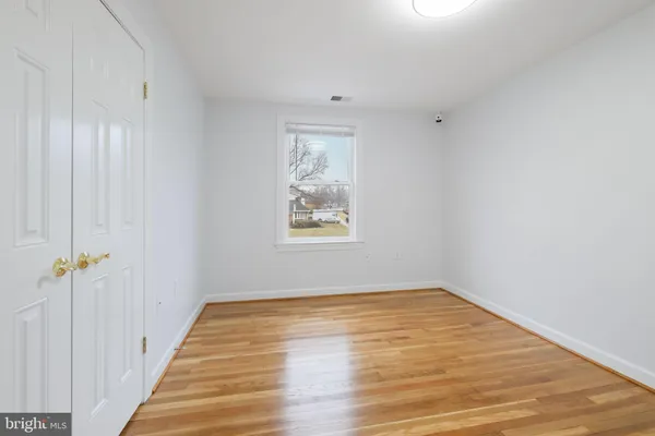 a view of empty room with wooden floor and fireplace