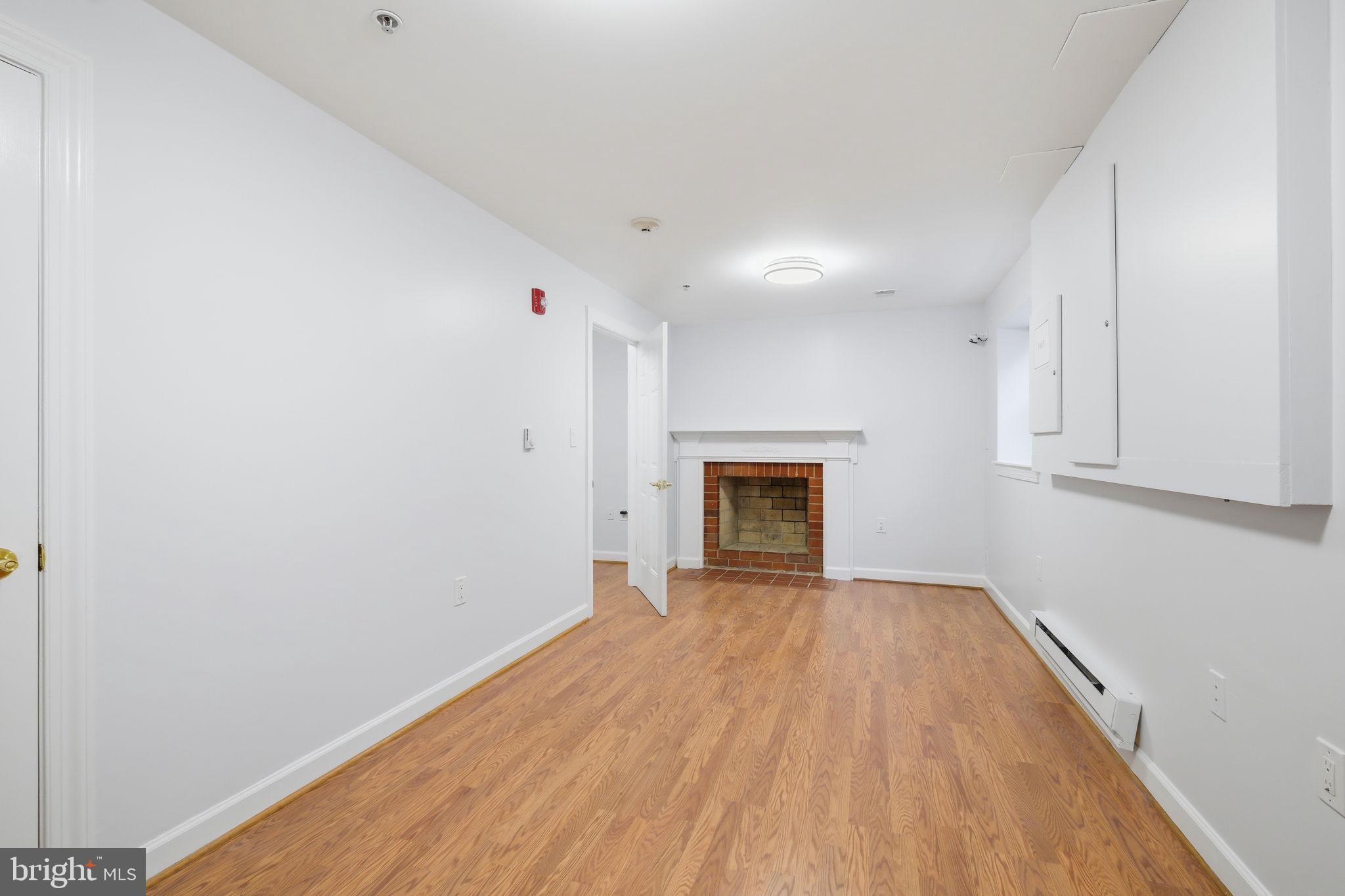 711 Lamberton Drive Silver Spring, MD 20902 - Photo 44 of 60 a view of empty room with wooden floor and fireplace