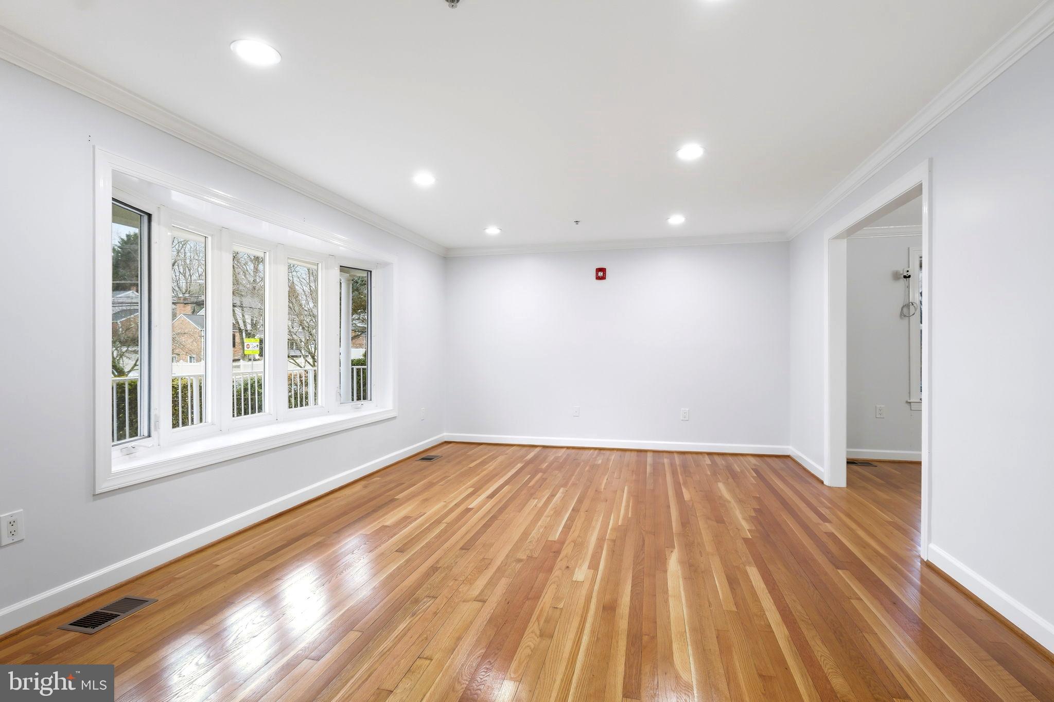 711 Lamberton Drive Silver Spring, MD 20902 - Photo 5 of 60 a view of an empty room with wooden floor and a window