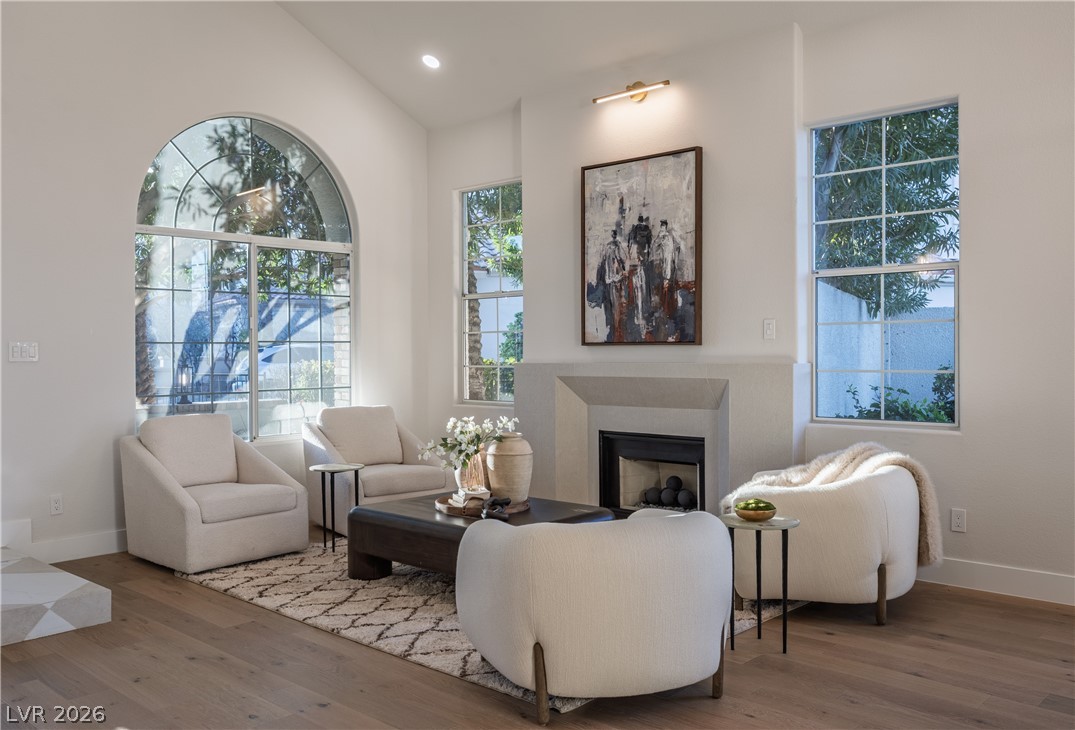 8800 Lusso Las Vegas, NV 89134 - Photo 19 of 85 Living area featuring a fireplace, hardwood / wood-style floors, vaulted ceiling, and healthy amount of natural light