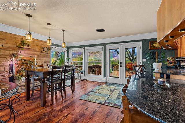 807 Fontmore Road Colorado Springs, CO 80904 - Photo 22 of 50 Dining area featuring french doors, dark hardwood / wood-style floors, plenty of natural light, and wood walls