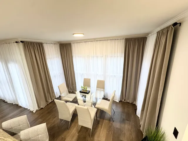 a living room with stainless steel appliances furniture a fireplace and a kitchen view