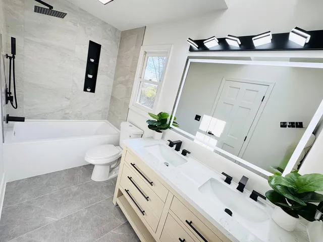 a bathroom with a bathtub a sink and a potted plant