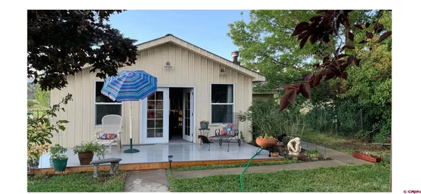 a front view of a house with garden and sitting area