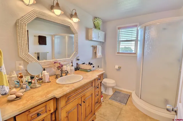 a bathroom with a granite countertop sink mirror vanity and toilet