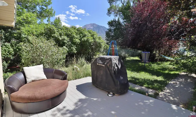 a view of a couches in the patio next to a yard