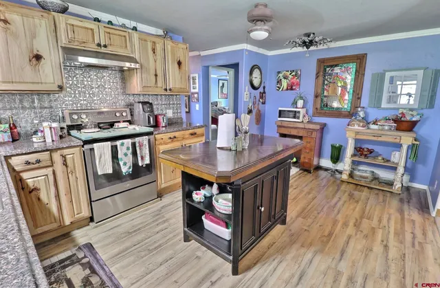 a kitchen with stainless steel appliances granite countertop a stove a sink dishwasher and cabinets with wooden floor