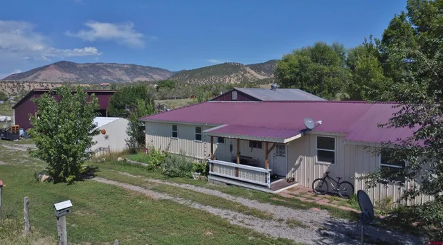 a view of a house with a yard and sitting area