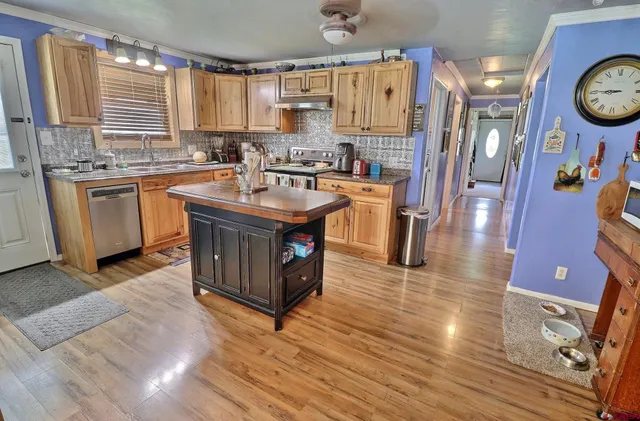 a kitchen with stainless steel appliances granite countertop a sink a stove and a refrigerator