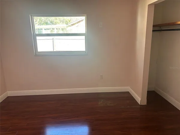 an empty room with wooden floor and a window