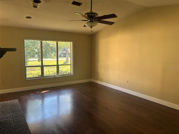 wooden floor in an empty room with a window