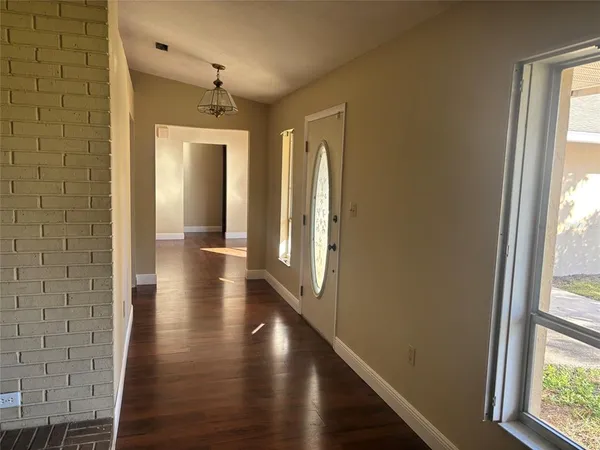 a view of a hallway with wooden floor and glass door