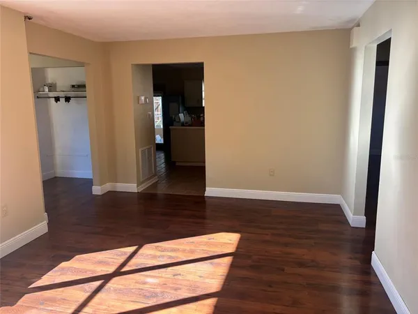 an empty room with wooden floor and entrance