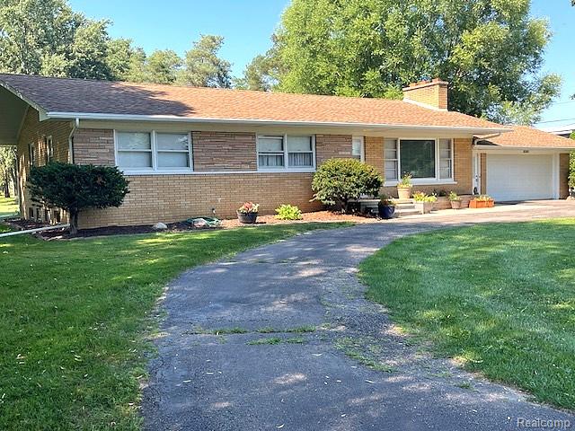 20285 29 Mile Road Ray, MI 48096 - Photo 1 of 25 Ranch-style residence featuring a brick and stone facade, shingle roof, attached garage with a white door, and a curved asphalt driveway