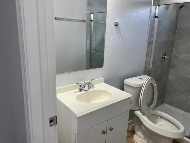 a bathroom with a sink toilet and shower