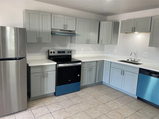 a kitchen with a stove sink and refrigerator