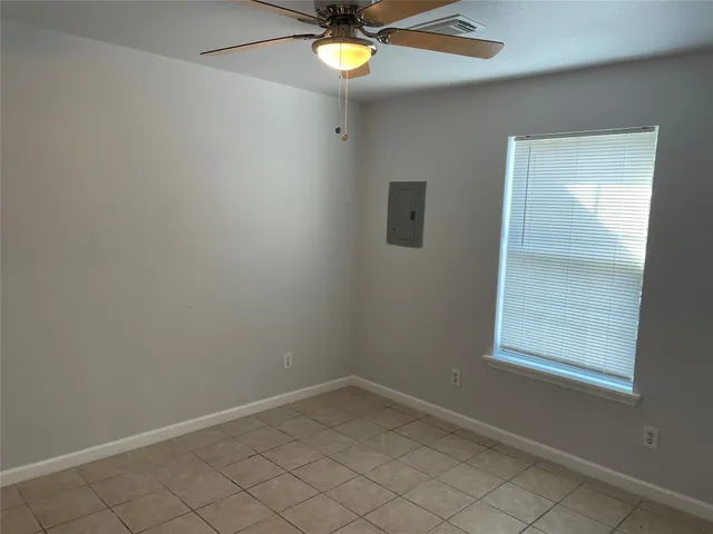 an empty room with a window and a fan