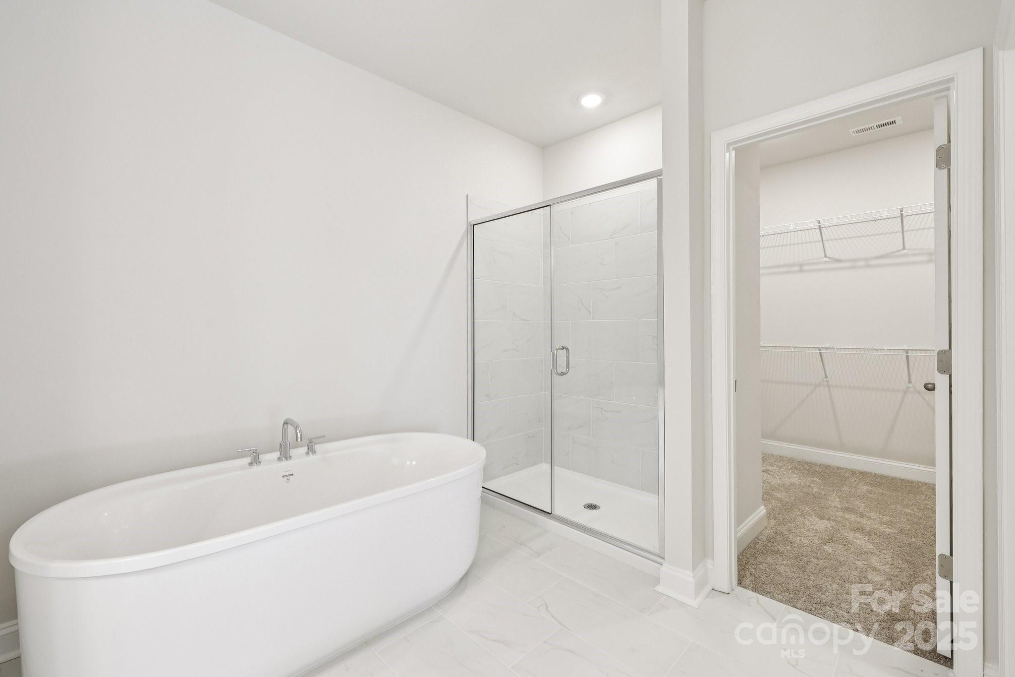 9612 Pointer Road, Unit 59 Huntersville, NC 28078 - Photo 33 of 43 a white bath tub sitting next to a shower