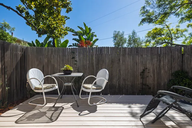 a view of a balcony with chairs and wooden floor