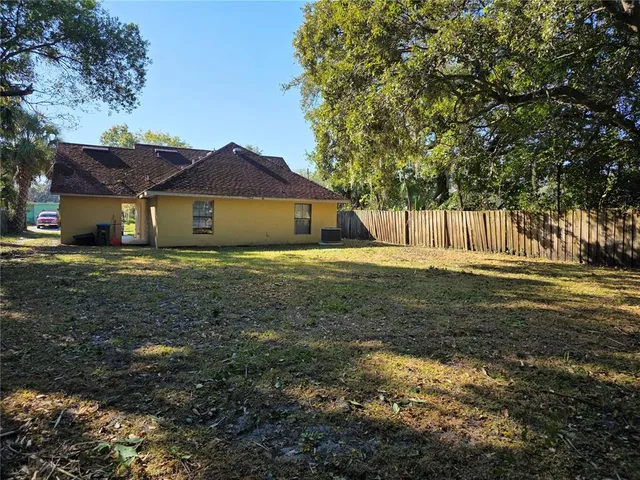 a big white house with a big yard and large trees