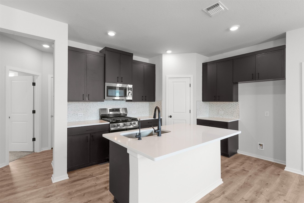 101 Coyote Willow Way Georgetown, TX 78633 - Photo 13 of 34 a kitchen that has a sink and a stove in it