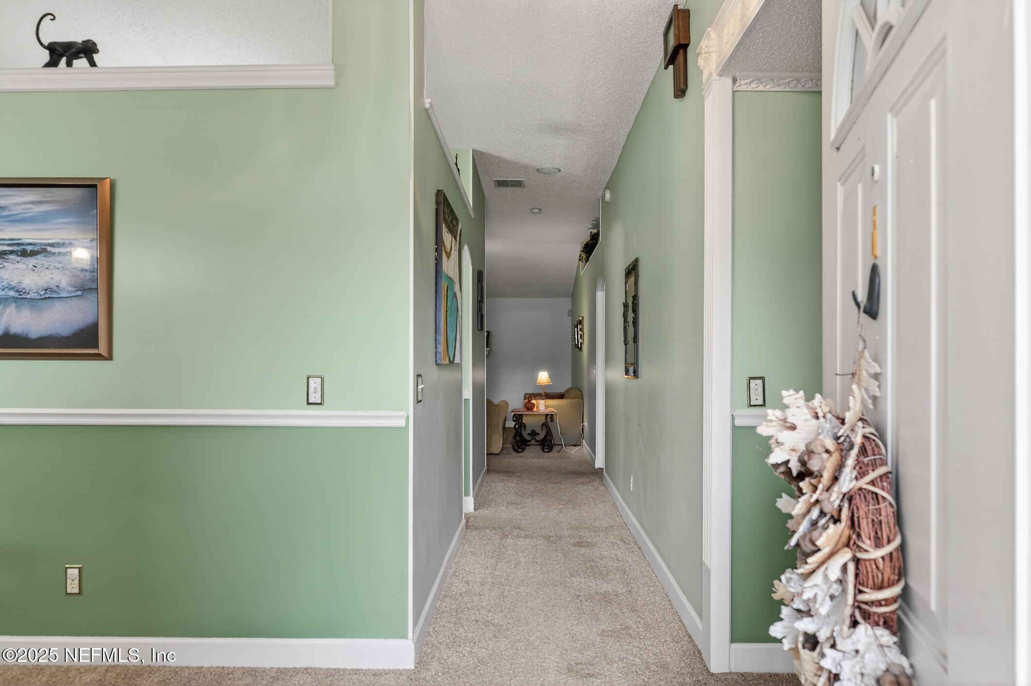 701 Camp Francis Johnson Road Orange Park, FL 32065 - Photo 4 of 64 a view of a hallway to a livingroom with furniture and a potted plant