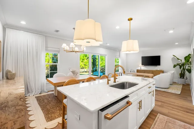 a kitchen with stainless steel appliances granite countertop a sink a stove and a wooden floor