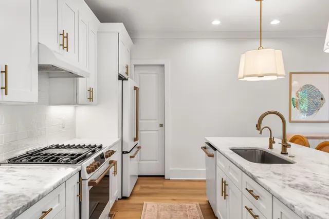 a kitchen with stainless steel appliances a sink a stove and a refrigerator