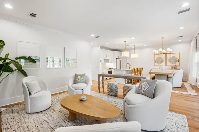a living room with furniture white walls and kitchen view