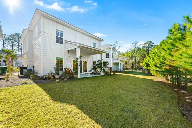 a view of a house with backyard and sitting area