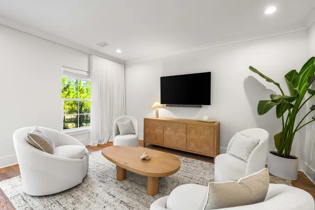 a living room with furniture a window and a flat screen tv