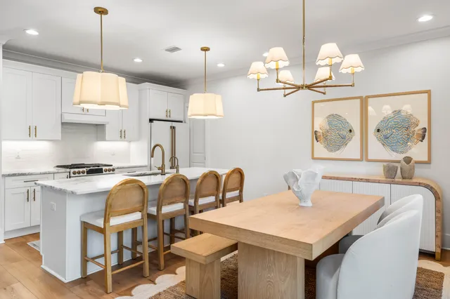 a kitchen with stainless steel appliances granite countertop a sink a stove a dining table and chairs