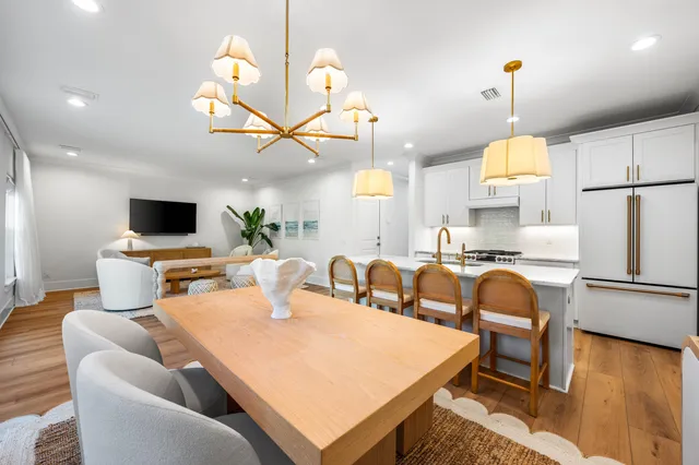 a living room with furniture a flat screen tv and kitchen view