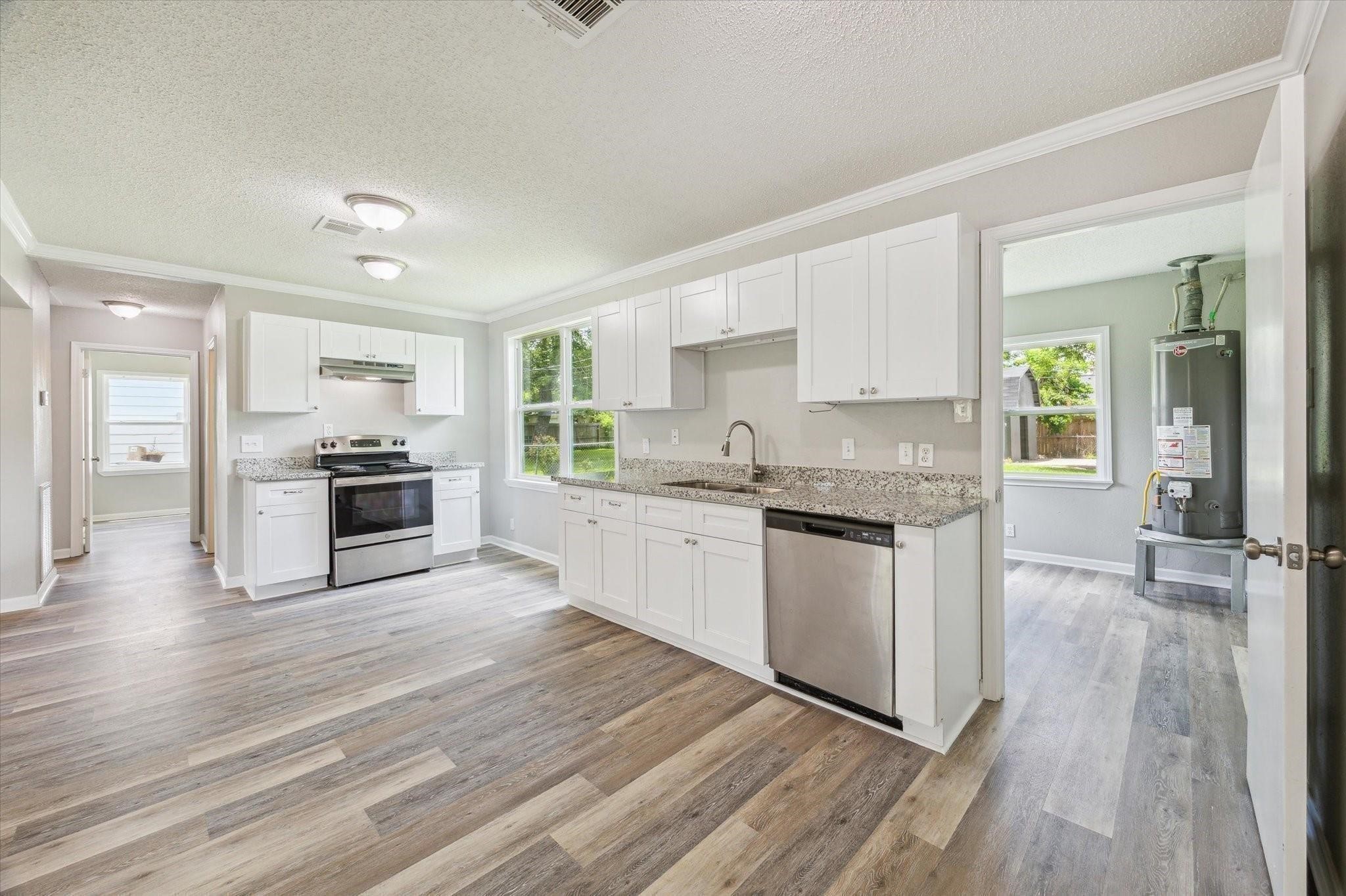 210 Laurel Street Lake Jackson, TX 77566 - Photo 5 of 13 a kitchen with granite countertop stainless steel appliances and wooden cabinets