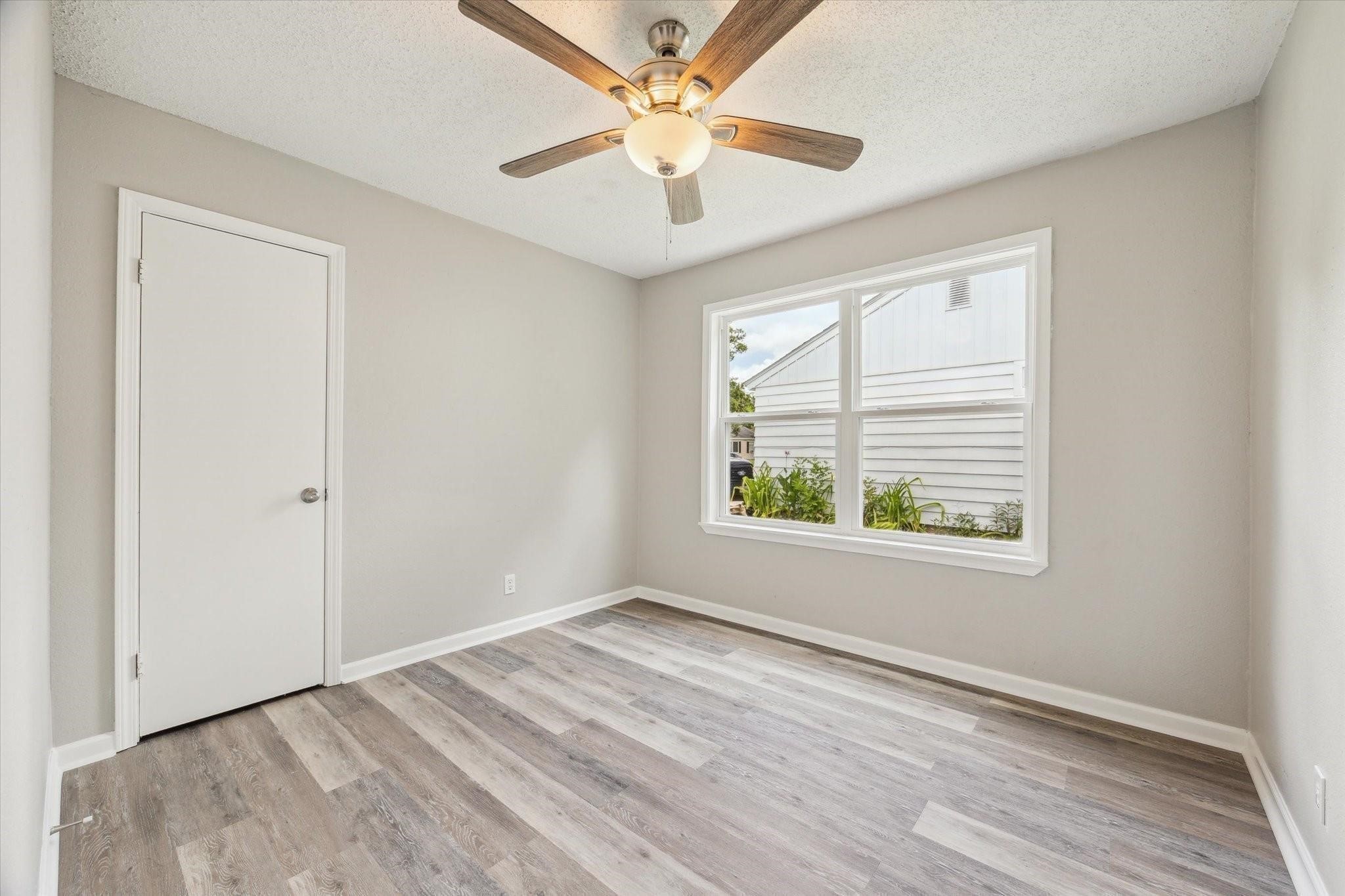 210 Laurel Street Lake Jackson, TX 77566 - Photo 7 of 13 wooden floor in an empty room with a window