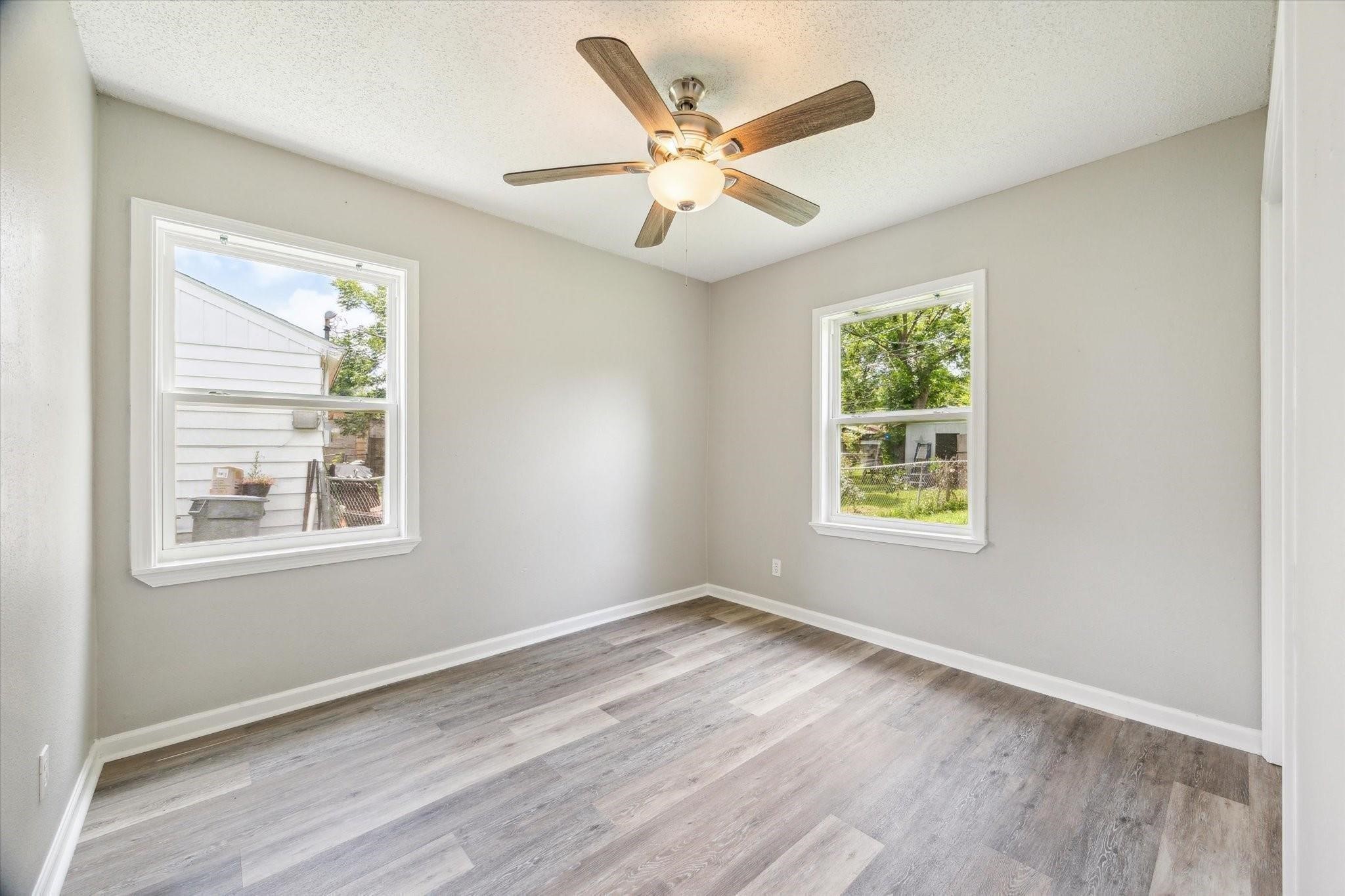 210 Laurel Street Lake Jackson, TX 77566 - Photo 8 of 13 an empty room with wooden floor fan and windows