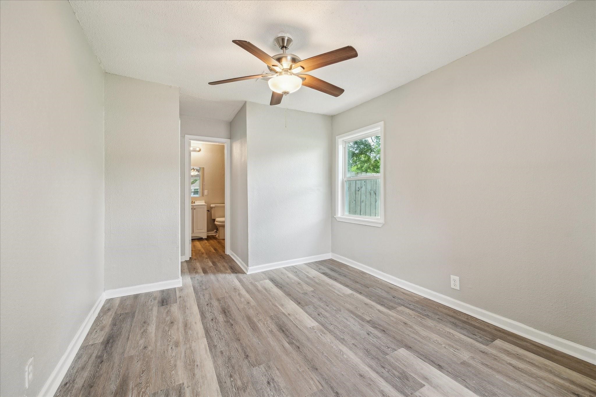 210 Laurel Street Lake Jackson, TX 77566 - Photo 9 of 13 a view of an empty room with wooden floor and a ceiling fan